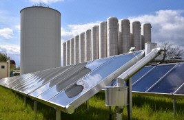 Solarthermie-Kollektorfeld an der Georgstraße, Chemnitz; im Hintergrund Zwei-Zonen-Wärmespeicher (links) und Fernwärme-Druckbehälterspeicher (rechts) Solare Fernwärme