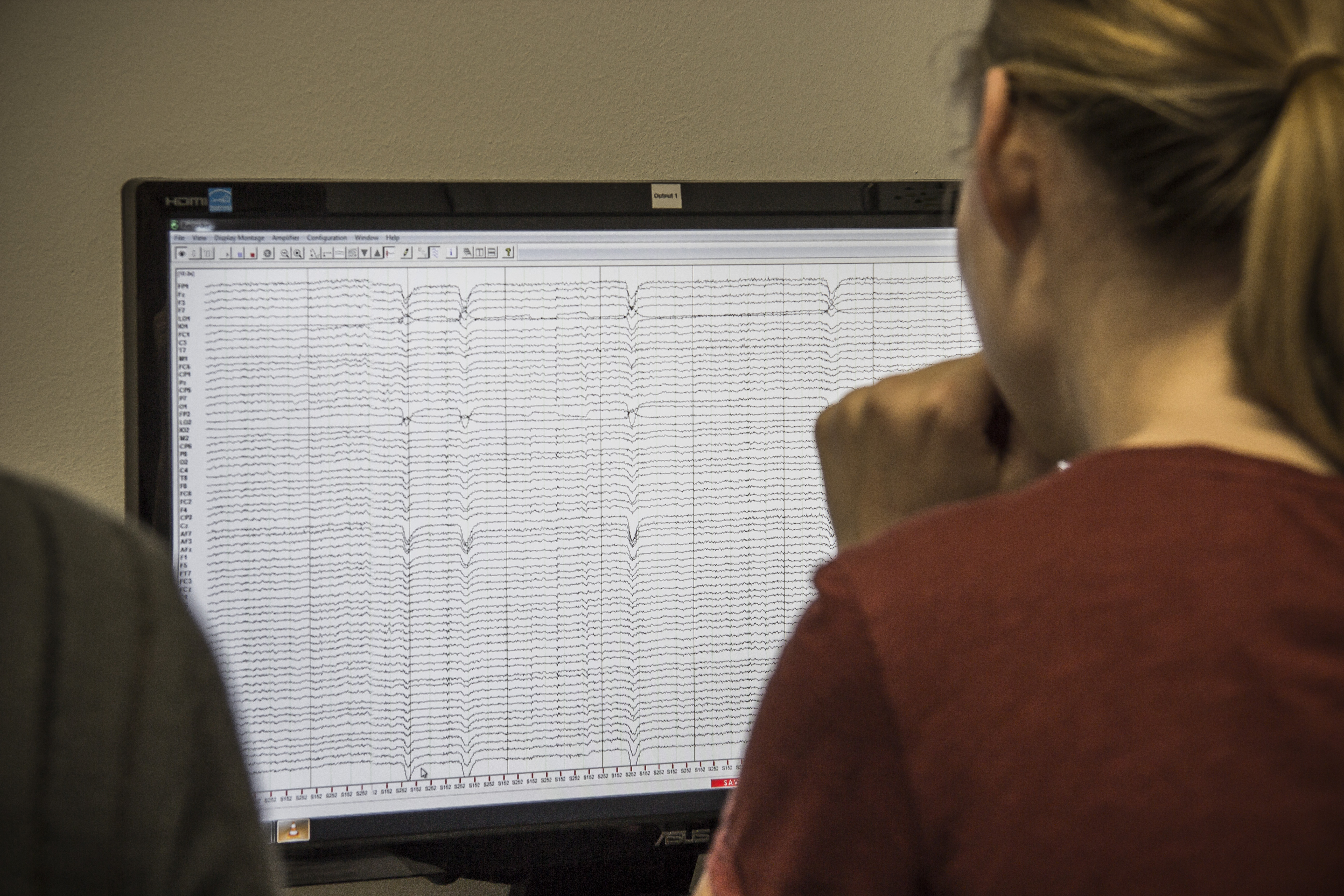Person betrachtet EEG-Daten auf einem Computermonitor