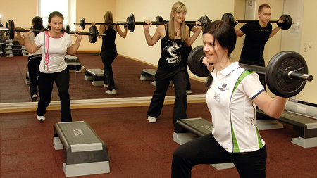 Studierende stemmen Gewichte im Fitnessstudio der TU.
