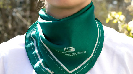 Eine Frau trägt ein Halstuch mit dem Logo der TU Chemnitz.