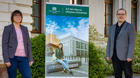 西装中的伊恩·弗劳·伊恩·曼和萨科·斯坦·内本·埃因姆·希尔德。Darauf steht Inkluaisve Hochschule学校。