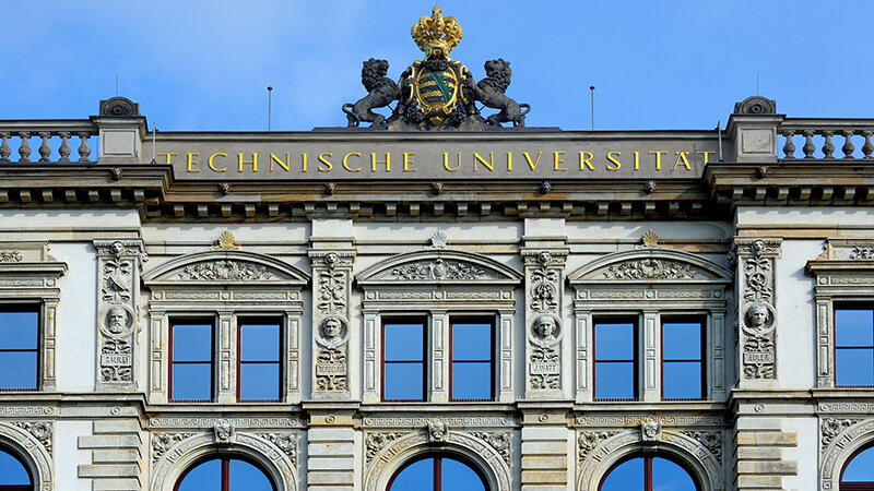 Ansicht des goldenen Schriftzuges Technische Universität und dem sächsischen Wappen aus dem Dach