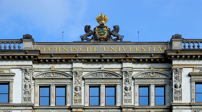 Ansicht des goldenen Schriftzuges Technische Universität und dem sächsischen Wappen aus dem Dach
