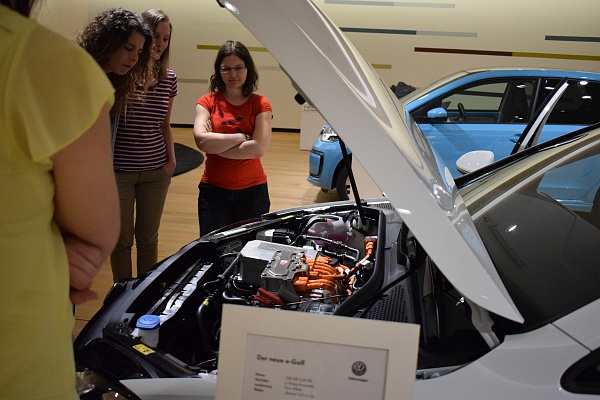 Mehrere Frauen schauen unter die Motorhaube eines Autos