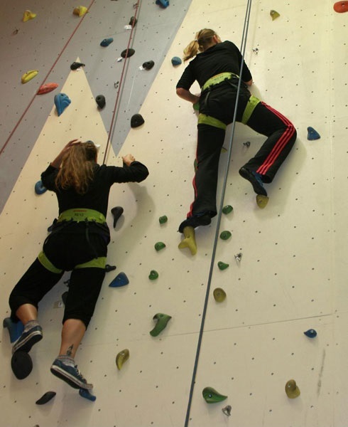 Zwei Studentinnen besteigen eine Kletterwand