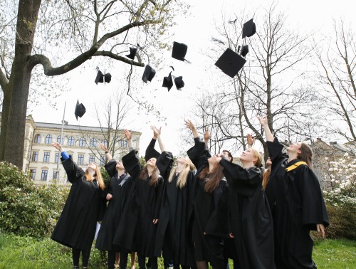 Women graduates throw their doctoral hats in the air
