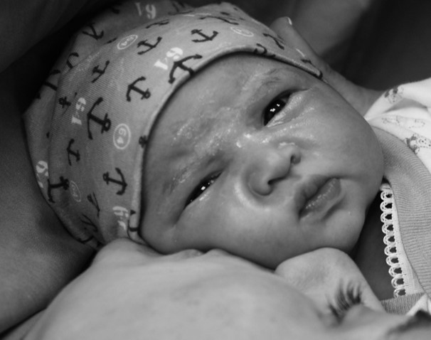 Foto eines Frühchens im Arm seiner Mutter