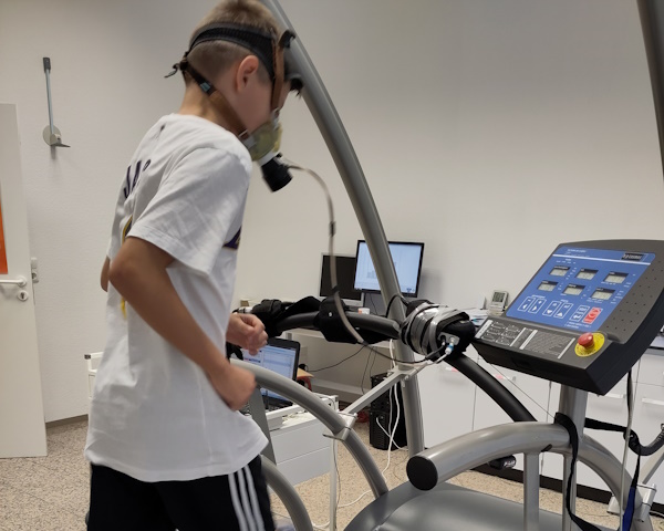 Kind läuft auf einem Laufband