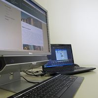 Computer screen and laptop on a desk