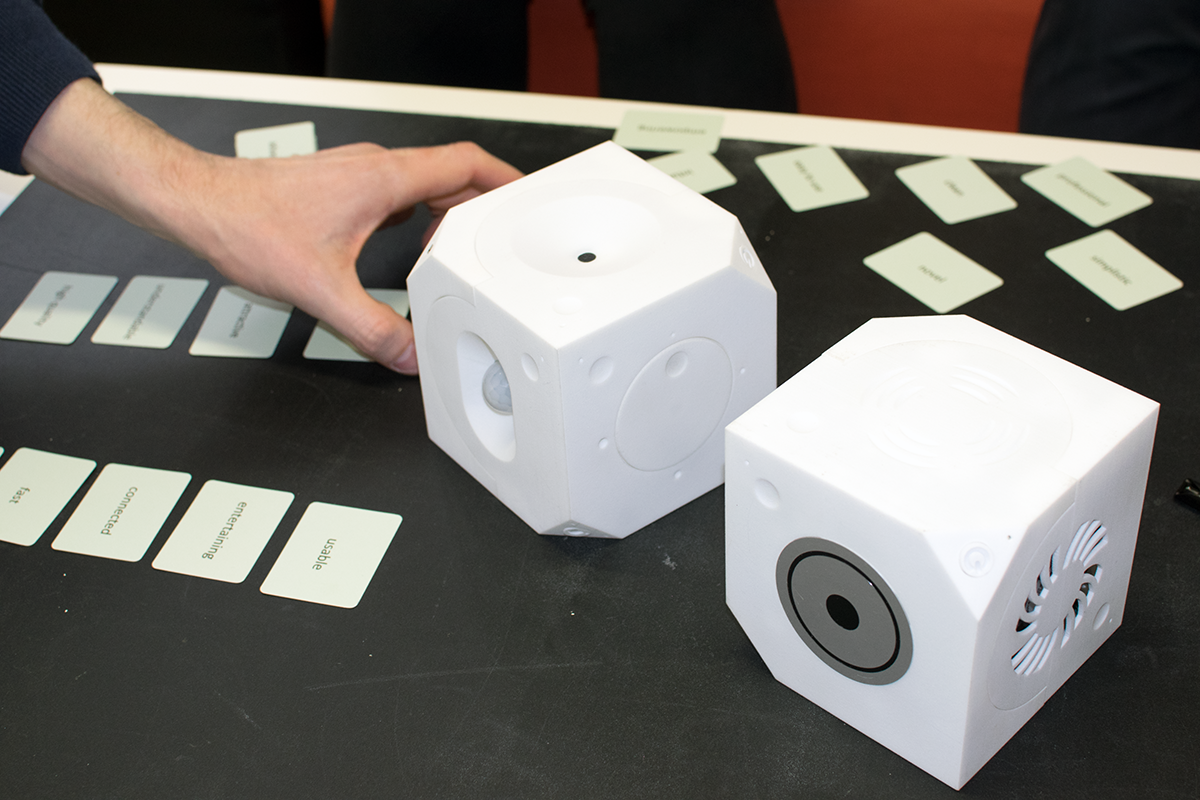 A hand sorts cards next to our Loaded Dice. The cards contain one word on each face and have a green background for positive words or a red background for negative words.