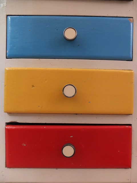 Abbildung eines Schubfachschranks mit einem blauen, einem gelben und einem roten Schubfach