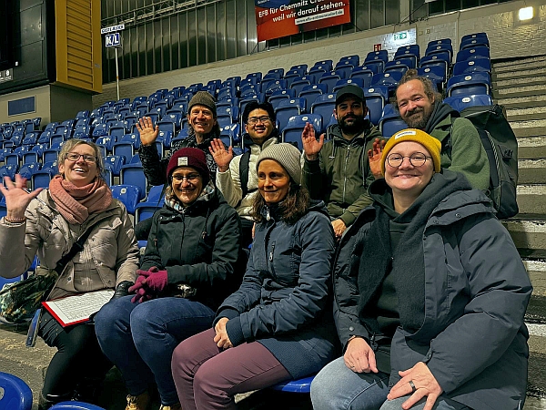 Das FMT-Team beim Eisstockschießen - Gruppenfoto der Teilnehmerinnen und Teilnehmer auf der Tribüne
