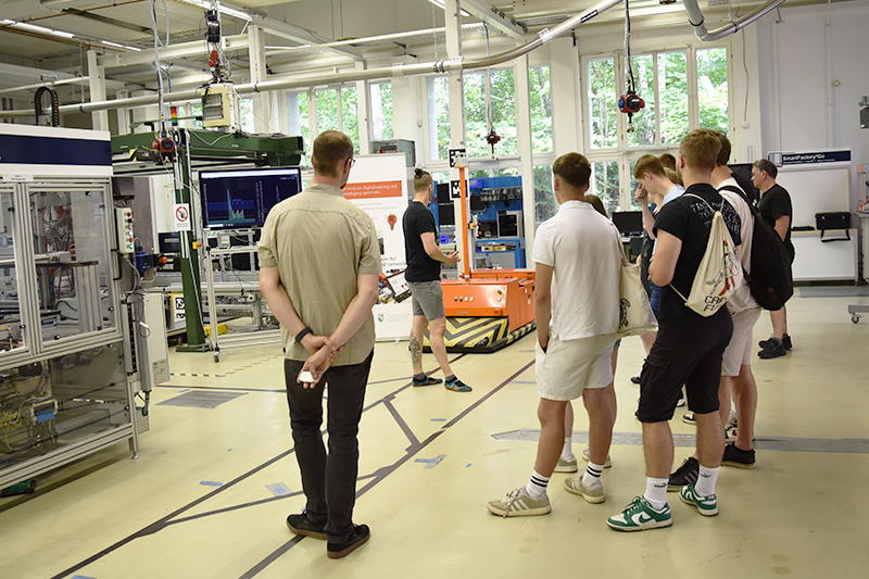 Schülerinnen und Schüler des Beruflichen Schulzentrums Werdau machen einen Rundgang durch die Experimentier- und Digitalfabrik der Professur Fabrikplanung und Intralogistik.