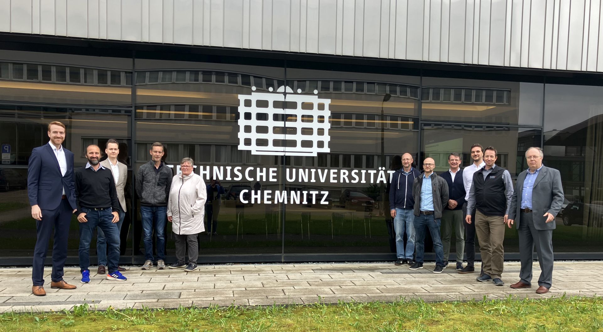 Teilnehmer der AWT-Sitzung stehen in einer Gruppe vor dem Uni-Gebäude M