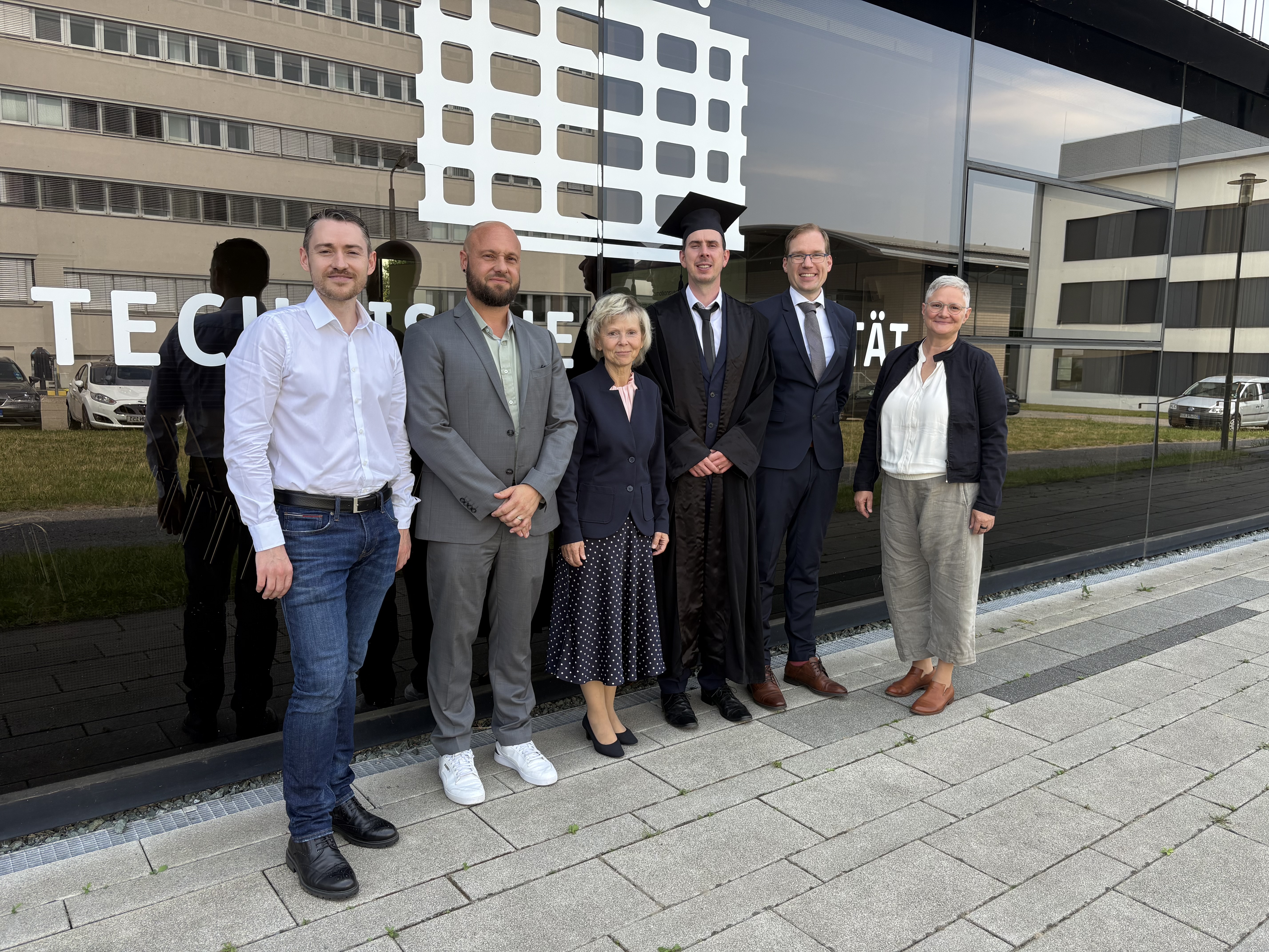 Eine Gruppe von Leuten steht vor dem Haus M der TUC