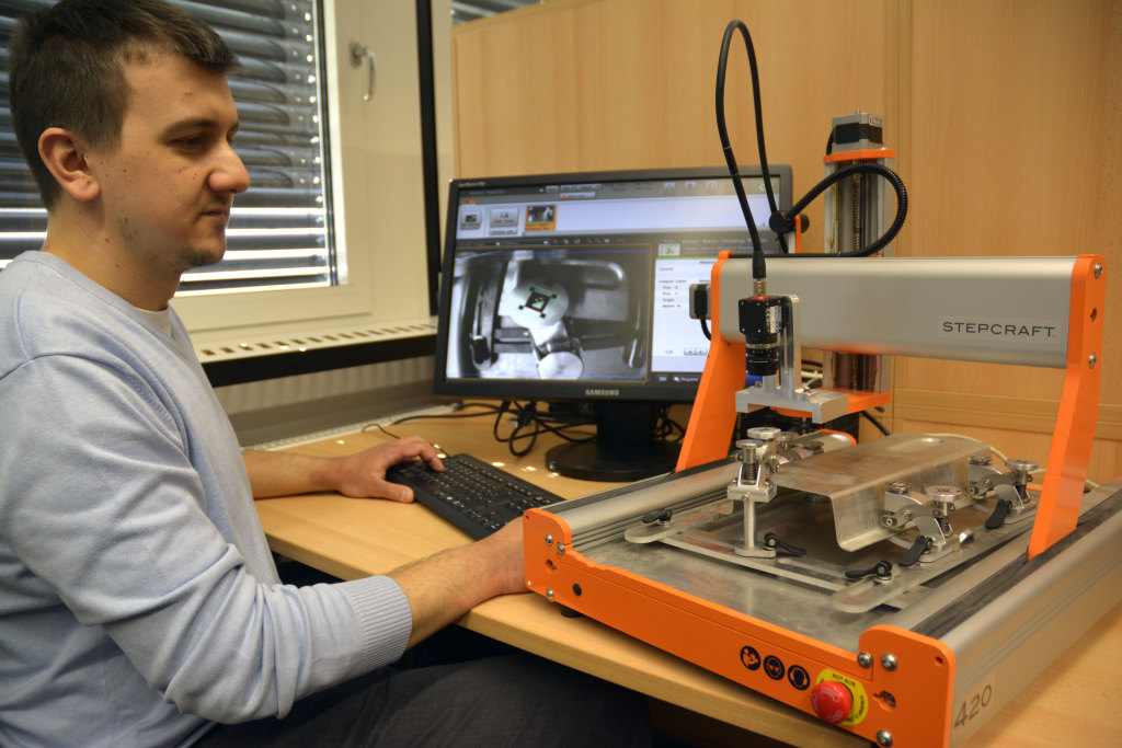 Nermin Redžić, wissenschaftlicher Mitarbeiter der Professur Produktionssysteme und -prozesse, testet den Demonstrator zur effizienten Teilepositionierung beim 3D-Wasserstrahlschneiden. Foto: TU Chemnitz/Katja Klöden