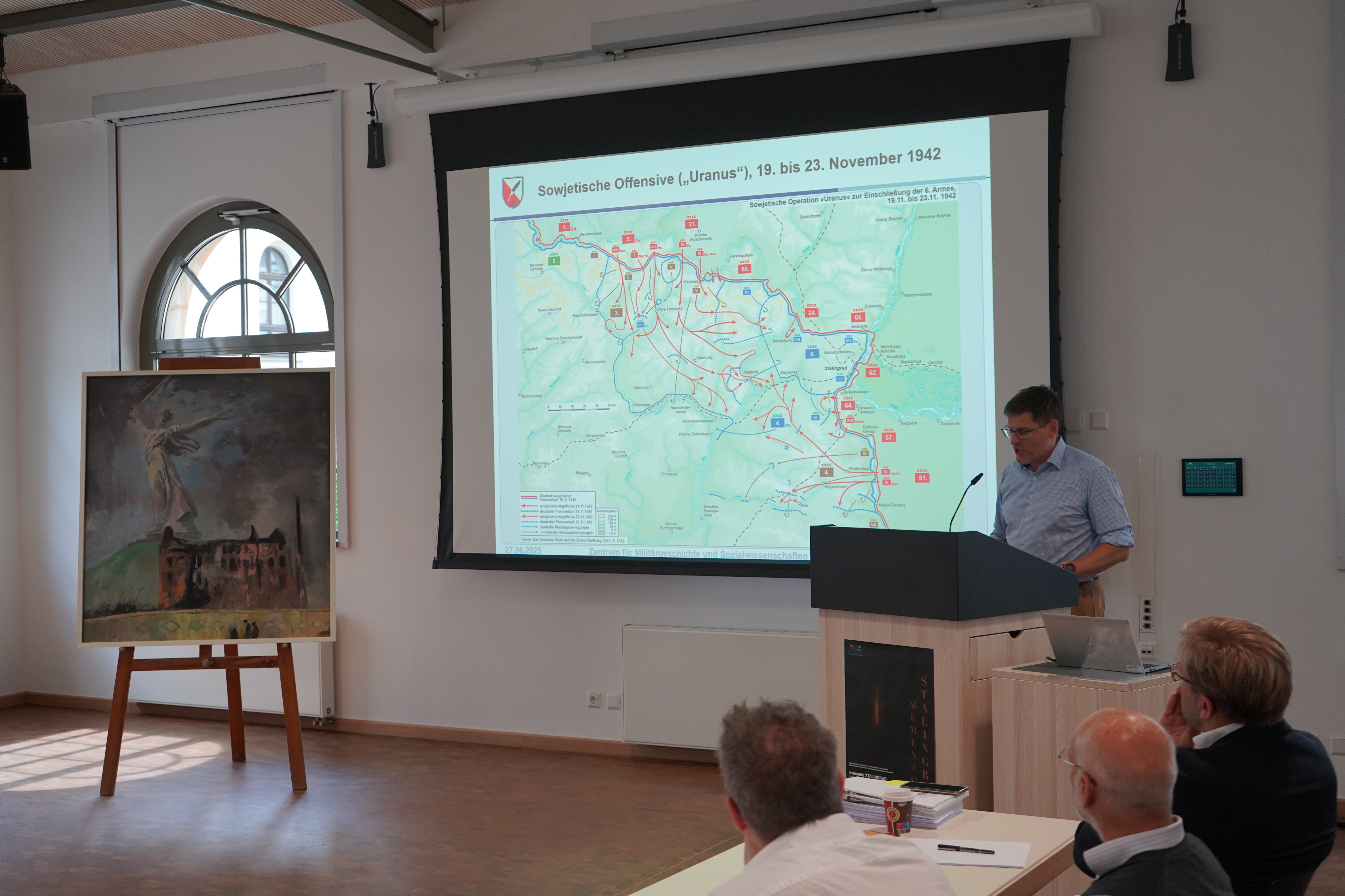 Peter Lieb stellt den Verlauf der Schlacht von Stalingrad dar, links im Bild das Gemälde: „Die Wolgograd-Erfahrung: Die Mühle“ (1977) des Malers Axel Wunsch; auf einer Leinwand ist ein schematischer Schlachtverlauf zu sehen