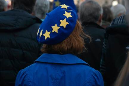 Frau mit einer Europa-Mütze steht in einer Menschenmenge