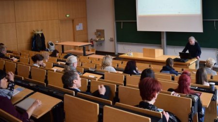 Viele Personen sitzen in einem Hörsaal.