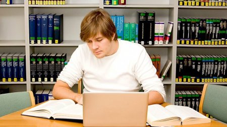 Ein Student wertet in einem Raum der Universitätsbibliothek Literatur aus.