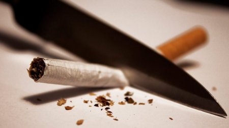Symbolfoto: Mit einem Messer wird eine Zigarette durchgeschnitten.