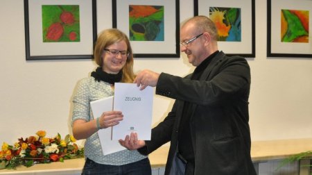 Studiengangsleiter Prof. Dr. Stephan Mühlig übergibt Anke Löschner ihr Zeugnis.