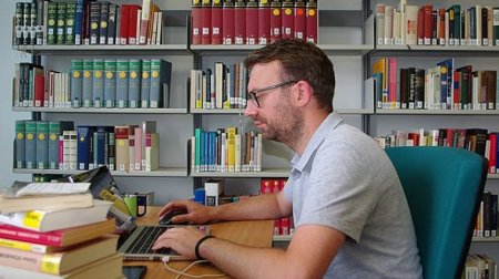 Junger Mann sitzt vor Computer.