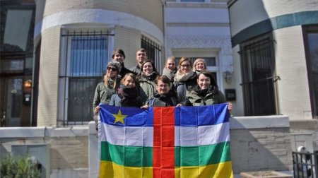 Zehn junge Frauen und Männer halten die Flagge der Zentralafrikanischen Republik.