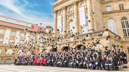 Group photo of the graduates together with the University President in front of the Opera House