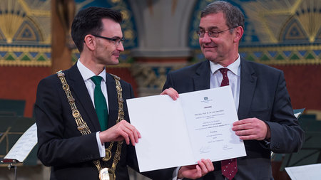 TU-Rektor Gerd Strohmeier übergibt Prof. Dr. Uwe Götze eine Urkunde