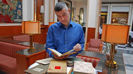Prof. Dr. Christoph Fasbender liest in einem Buch