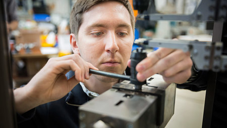 Mann arbeitet an einer Maschine