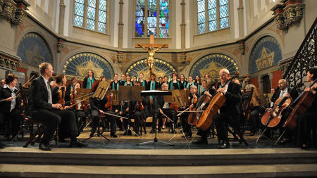 Universitätschor und -orchester musizieren gemeinsam vor dem Altar der St. Petrikirche