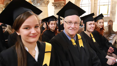 Bild mehrerer Graduierter, welche Talare tragen