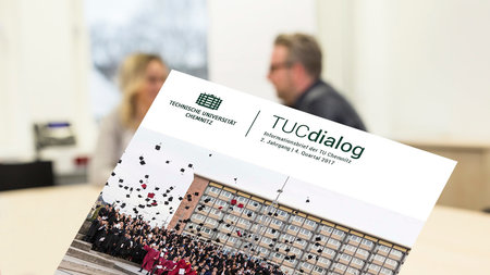 Der neue Newsletter TUDdialog wird gezeigt, im Hintergrund unterhalten sich zwei Personen.