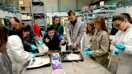 Schüler stellen im Labor Gipshängemodelle her und tragen dabei Schutzkleidung.