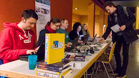 Mitarbeitende des Universitätsrechenzentrums und der Universitätsbibliothek beraten einen Gast.