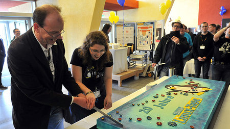 Ein Kuchen mit dem Logo der Chemnitzer Linux-Tage wird angeschnitten.