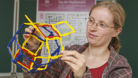 Junge Frau baut einen Pseudo-Rhombenkuboktaeder zusammen.