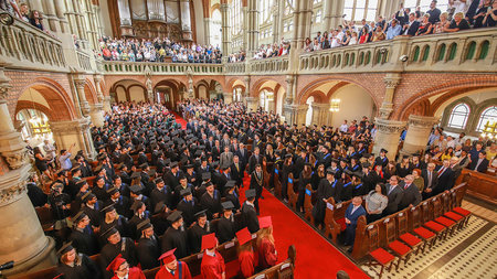 Graduierte sitzen in Talar und Barett gekliedet in der St- Petrikirche