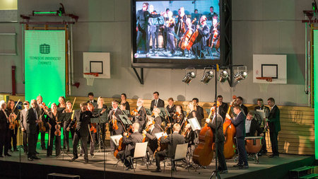 Orchestermitglieder musizieren auf einer Bühne in der Hartmann-Halle