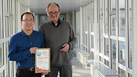 Young asian man and older man are holding a certificate.