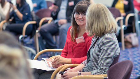 Zwei Frauen unterhalten sich in einem Konferenzraum