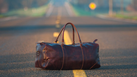 Reisetasche steht auf einer Straße