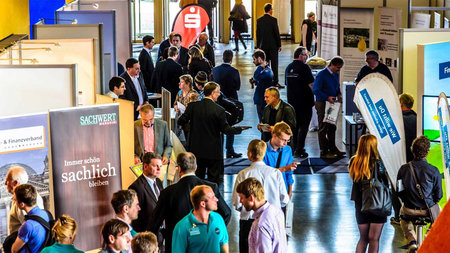 Aussteller und Besucher im Gespräch im Foyer des Hörsaalgebäudes