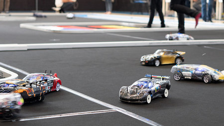 Rennwagen im Miniaturformat fahren auf einer Rennbahn.