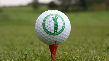 Golfball mit Logo des Vereins Ictus Academicus liegt auf dem Rasen