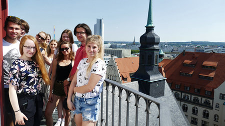 Mehrere Personen stehen auf der Besucherplattform des Chemnitzer rathausturms und blicken auf die Stadt.