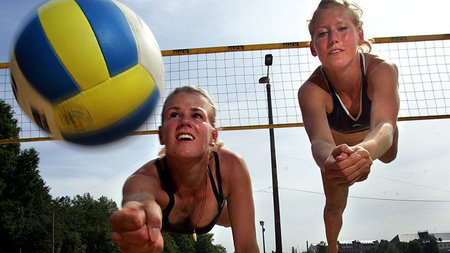 Zwei Volleyballerinnen hechten sich zum Ball