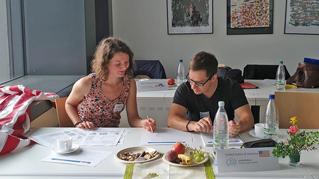 Eine junge Frau und ein junger Mann studieren ein Papier.